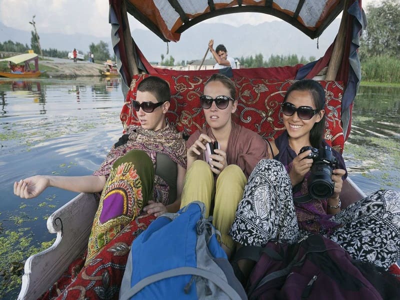 A group of tourists enjoying the scenic landscapes of Kashmir on a tour